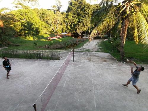 two people playing a game of volleyball on a court at Mulu Diana Homestay in Mulu