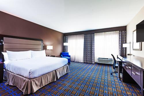 a hotel room with a bed and a desk at Clarion Hotel The Colony - Plano West in The Colony
