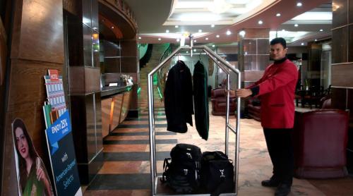 a man standing next to a clothes rack in a store at Hotel Victory - Best in City Center in Dhaka