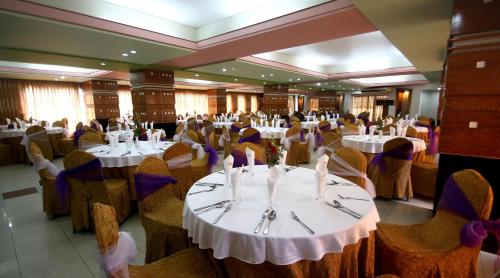 a dining room with tables and chairs with people sitting at them at Hotel Victory - Best in City Center in Dhaka