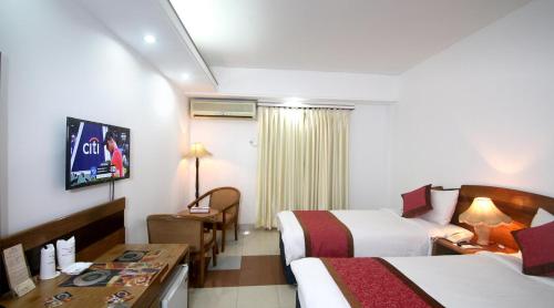 a hotel room with two beds and a television at Hotel Victory - Best in City Center in Dhaka