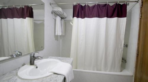 La salle de bains est pourvue d'un lavabo et d'un rideau de douche. dans l'établissement Hotel Victory - Best in City Center, à Dhaka