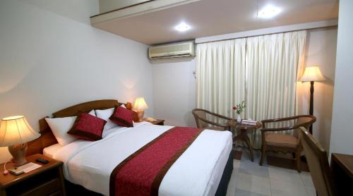 a hotel room with a bed and a table and chairs at Hotel Victory - Best in City Center in Dhaka