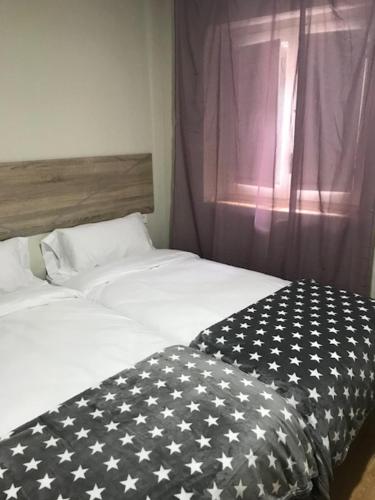 a bed with a black and white blanket on it at APT4 Encantador al Centre de Vic APTGARBI in Vic