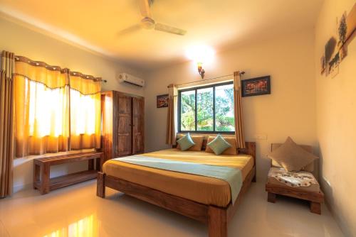 a bedroom with a large bed and a window at Monarch Suites in Candolim