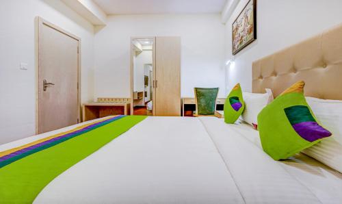 a bedroom with a large white bed with colorful pillows at Treebo Galaxy Suites Mathikere in Bengaluru
