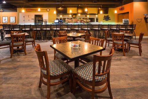 a restaurant with tables and chairs and a bar at Holiday Inn Detroit Lakes by IHG in Detroit Lakes
