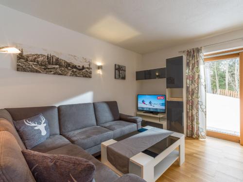 uma sala de estar com um sofá e uma televisão em Ferienwohnung Prama em Going