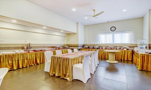 a banquet hall with tables and chairs and a clock at Treebo Galaxy Suites Mathikere in Bengaluru