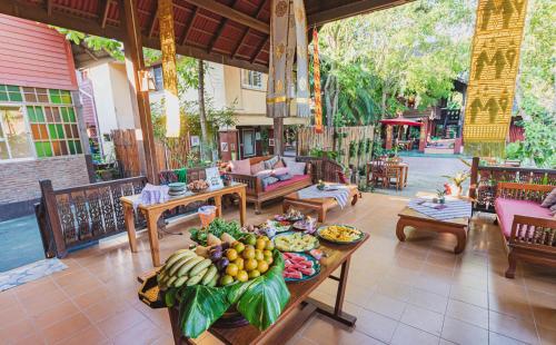una mesa llena de fruta en el patio en Joy's House & Tour, en Chiang Mai