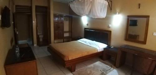 MorogoroにあるHotel Oasisの小さなベッドルーム(ベッド1台、鏡付)
