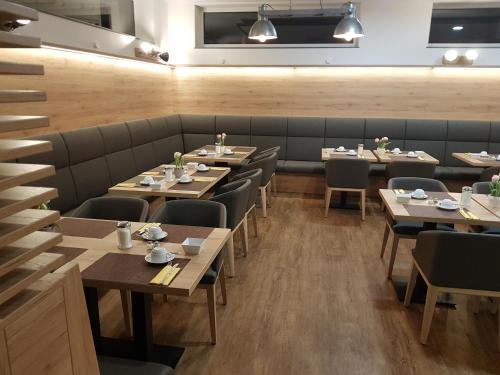 a row of tables and chairs in a restaurant at Hotel PrimaVera parco in Fürth