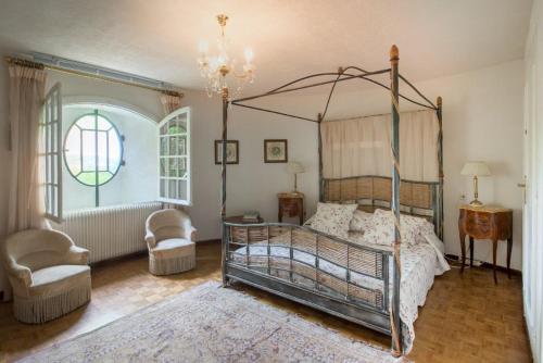 1 dormitorio con 1 cama con dosel y 2 sillas en Villa with pool in Provence -Villa Romantique sleeps up to 12 4 in optional gite, en Beaucaire