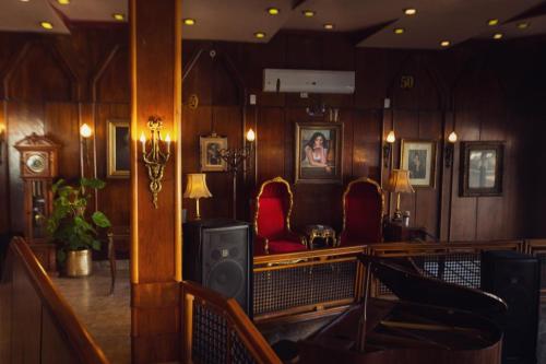 a room with wooden walls and red chairs and a bar at San Giovanni Stanly Hotel in Alexandria