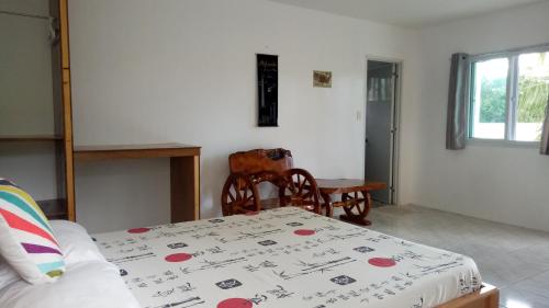 a room with a bed and a table and a window at Kathleens Vacation Place in Moalboal