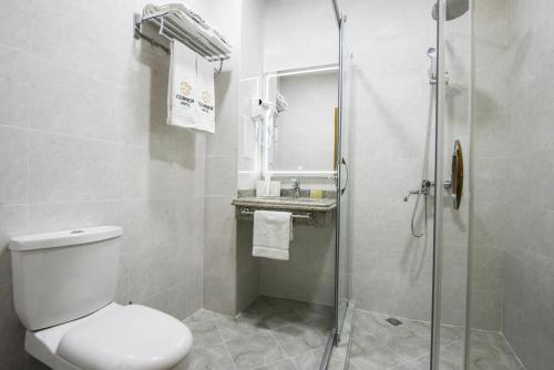 a bathroom with a toilet and a glass shower at Corner Hotel Tashkent in Tashkent