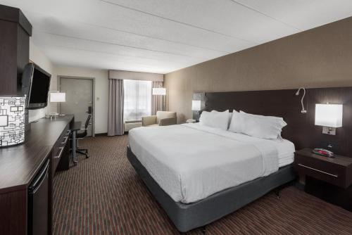a hotel room with a large bed and a desk at Holiday Inn At Six Flags Saint Louis by IHG in Eureka