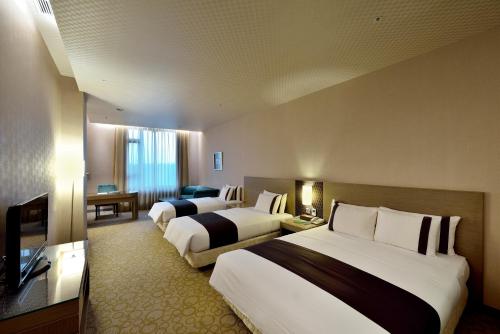 台中市にあるShinkansen Grand Hotelのベッド2台とテレビがあるホテルの部屋