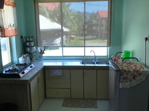 cocina con fregadero y ventana en Malinja Homestay, en Kuah