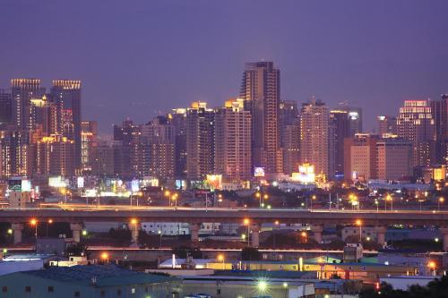 a city skyline at night with a bridge and buildings at Shinkansen Grand Hotel in Taichung