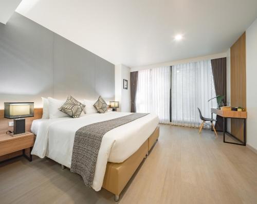 a hotel room with a large bed and a desk at Nap in Chiangmai in Chiang Mai