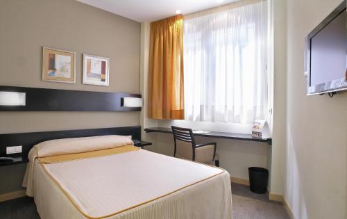 um quarto de hotel com uma cama e uma janela em Blu Hotel Pamplona em Imárcoain