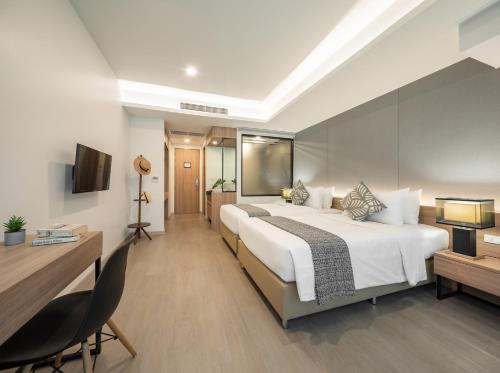 a hotel room with a large bed and a desk at Nap in Chiangmai in Chiang Mai