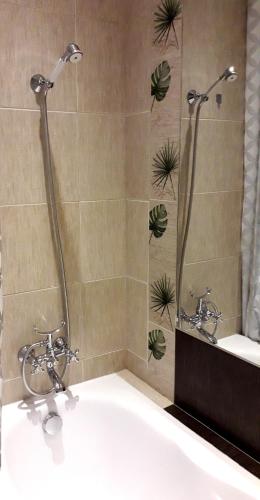 a bathroom with a bath tub and a sink at Apartament Centrum przy Maxie in Tarnów