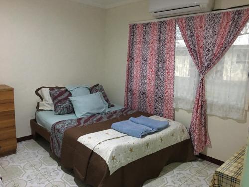 a bedroom with a bed and a window with curtains at Mapusagas Riverside x2Bedrooms Home away from home #4 Sleeps 2-6 in Apia