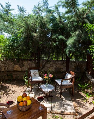 a table with a bowl of fruit and two glasses of wine at Mandarin & Mango Boutique Hotel in Faralya