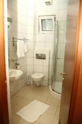 a bathroom with a toilet and a sink and a shower at Euro House Hotel in Baia Mare