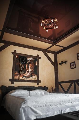 a bedroom with a bed with a picture on the wall at Avto Spa in Khmelʼnytsʼkyy