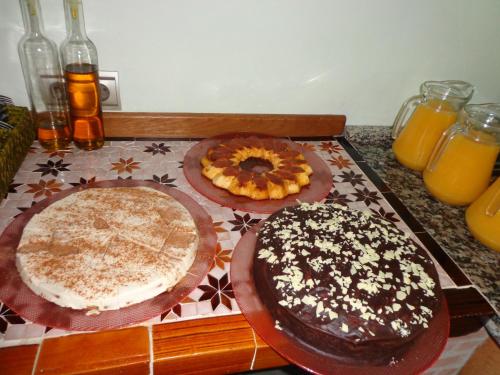 two cakes are sitting on a counter with orange juice at Estrella de las Nieves in Pampaneira