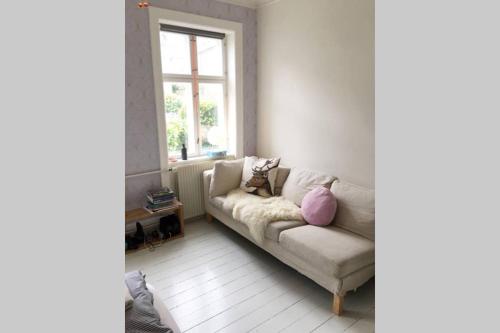 sala de estar con sofá y ventana en Central Apartment in attractive Østerbro en Copenhague