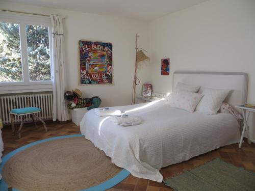 a bedroom with a large white bed and a window at La Clorinde in Moustiers-Sainte-Marie