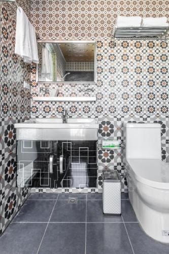 a bathroom with a sink and a toilet at Mambo Boutique Hotel in Hengchun