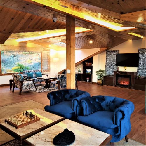 a living room with two blue couches and a chess board at The Retreat Mashobra, Shimla in Shimla