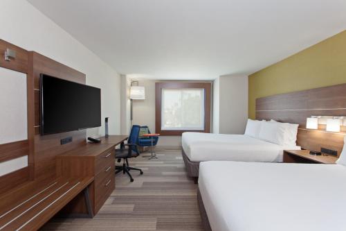 a hotel room with two beds and a flat screen tv at Holiday Inn Express & Suites Pasadena - Los Angeles by IHG in Pasadena