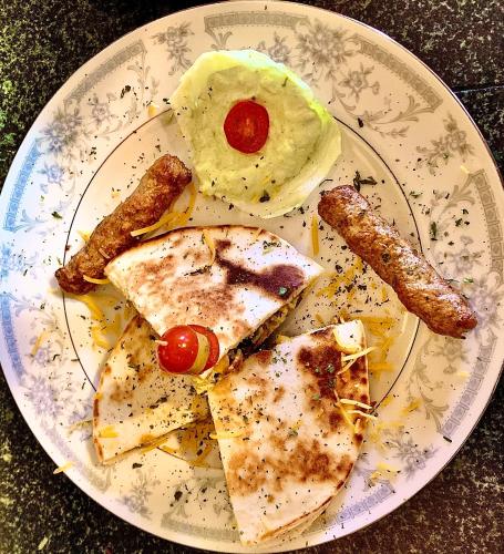 a plate of food with meat and eggs and sausage at Peace & Plenty Inn Bed and Breakfast Downtown St Augustine-Adults Only in Saint Augustine