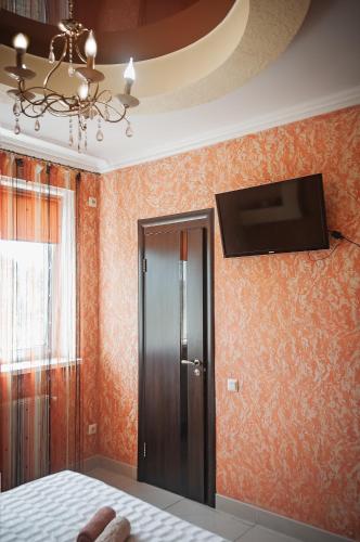 a bedroom with orange wallpaper and a tv on the wall at Avto Spa in Khmelʼnytsʼkyy