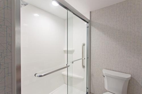 a glass shower door in a bathroom with a toilet at Holiday Inn Express & Suites Pasadena - Los Angeles by IHG in Pasadena
