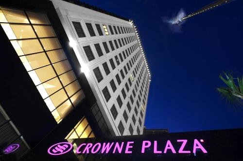 a tall building with a pink sign in front of it at Crowne Plaza Bursa Convention Center & Thermal Spa by IHG in Bursa