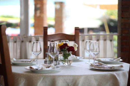 a white table with wine glasses and flowers on it at Resort Nord Park in Fushë-Krujë