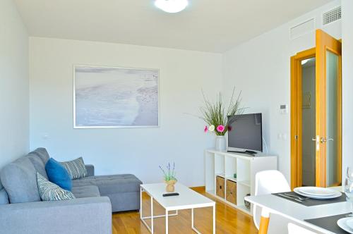 Una sala de estar con un sofá y un televisor. en Stay In Brisas del Sur, en Alicante