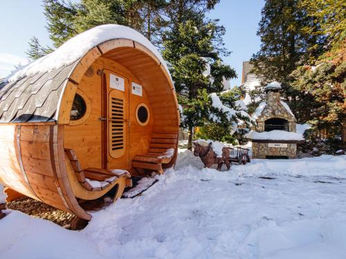a large wooden hobbit house in the snow at Aparthotel Delta Zakopane in Zakopane