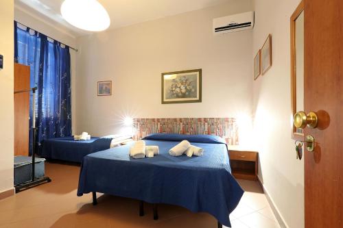a bedroom with two beds with blue sheets and towels at casa ros via ostiense 73 in Rome