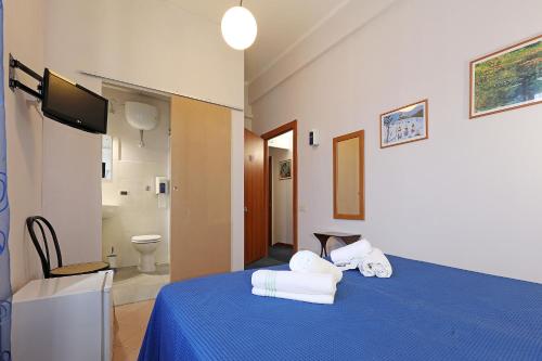 a bedroom with a blue bed with towels on it at casa ros via ostiense 73 in Rome