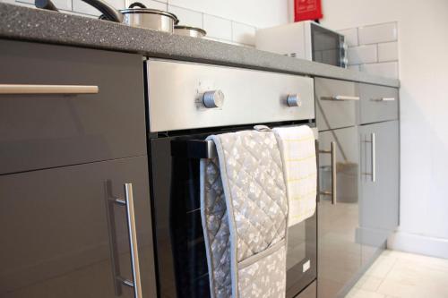 a kitchen with a stove with towels hanging on it at Flower In Hand Apartment in Norwich