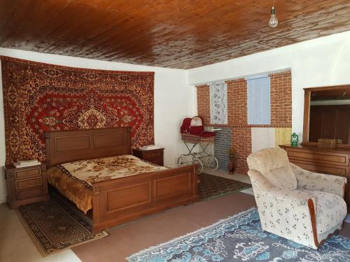 a bedroom with a bed and a chair at Rustic Inn "Koba's Sakhli" in Mestia