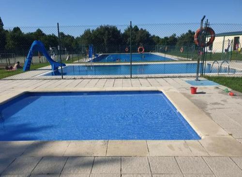 an empty swimming pool in a park with a playground at Casa Chuss in Sober
